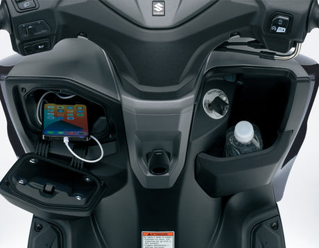 Suzuki Burgman Street EX 2023 storage compartment with USB charging port and cockpit view, modern scooter technology and comfort features